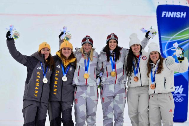 Gold medallists Austria's Ariane Raedler and Austria's Katharina Huber (C), silver medallists Germany's Kira Weidle-Winkelmann and Germany's Emma Aicher (L) and bronze medallists USA's Jacqueline Wiles and USA's A J Hurt (R) celebrate on the podium of the women's team combined event during the Milano Cortina 2026 Winter Olympic Games at the Tofane Alpine Skiing Centre in Cortina d’Ampezzo on February 10, 2026. (Photo by Stefano RELLANDINI / AFP)