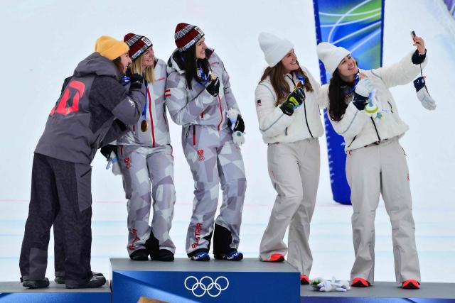 Gold medallists Austria's Ariane Raedler and Austria's Katharina Huber (C), silver medallists Germany's Kira Weidle-Winkelmann and Germany's Emma Aicher (L) and bronze medallists USA's Jacqueline Wiles and USA's A J Hurt (R) pose for a selfie on the podium of the women's team combined event during the Milano Cortina 2026 Winter Olympic Games at the Tofane Alpine Skiing Centre in Cortina d’Ampezzo on February 10, 2026. (Photo by Stefano RELLANDINI / AFP)