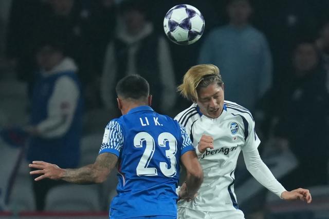 Machida Zelvia’s Shota Fujio (R) fights for the ball with Shanghai Shenhua’s Li Ke during their AFC Champions League football match in Shanghai on February 10, 2026. (Photo by CN-STR / AFP) / China OUT