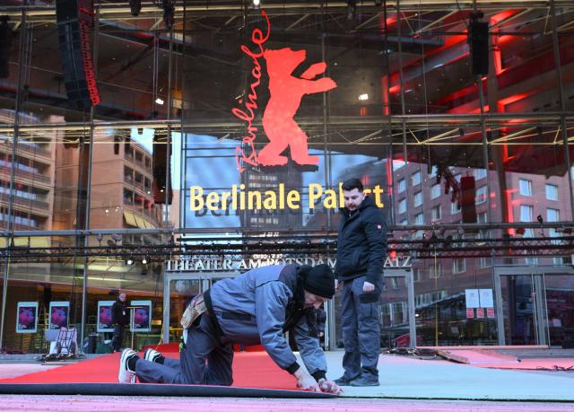Workers lay the red carpet in front of the Berlinale Palace as preparations are under way for the 76th Berlinale, Europe's first major film festival of the year, in Berlin on February 10, 2026. (Photo by RALF HIRSCHBERGER / AFP)
