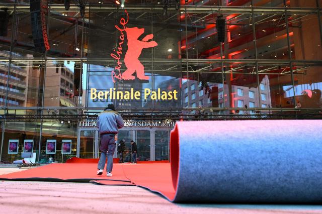 Workers lay the red carpet in front of the Berlinale Palace as preparations are under way for the 76th Berlinale, Europe's first major film festival of the year, in Berlin on February 10, 2026. (Photo by RALF HIRSCHBERGER / AFP)