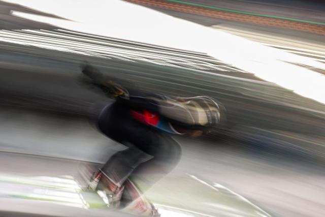 An athlete slides down the inrun track during the ski jumping mixed team trial round of the Milano Cortina 2026 Winter Olympic Games at Predazzo Ski Jumping Stadium in Predazzo (Val di Fiemme), on February 10, 2026. (Photo by Anne-Christine POUJOULAT / AFP)