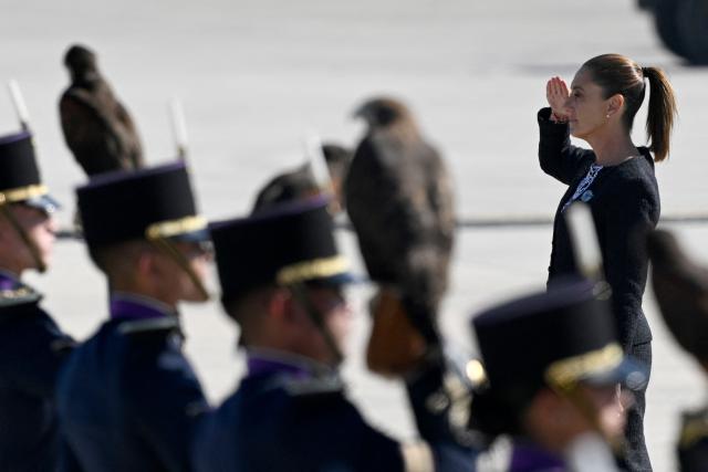 Mexico's President Claudia Sheinbaum salutes upon arrival for an Air Force ceremony marking its 111th anniversary at the Santa Lucia Air Force Base in Zumpango, near Mexico City, on February 10, 2026. (Photo by Alfredo ESTRELLA / AFP)