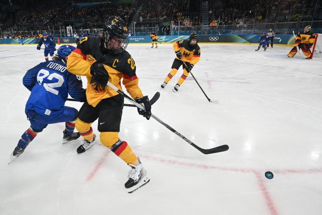 Germany's #20 Daria Gleissner (R) and Italy's #82 Kayla Tutino vie for the puck during the women's preliminary round Group B Ice Hockey match between Italy and Germany at the Milano Rho Ice Hockey Arena at the Milano Cortina 2026 Winter Olympic Games in Milan, on February 10, 2026. (Photo by PIERO CRUCIATTI / AFP)