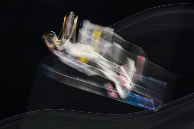 This slow shutter photograph shows Slovenia's Nika Prevc jumping during the ski jumping mixed team trial round of the Milano Cortina 2026 Winter Olympic Games at Predazzo Ski Jumping Stadium in Predazzo (Val di Fiemme), on February 10, 2026. (Photo by Javier SORIANO / AFP)