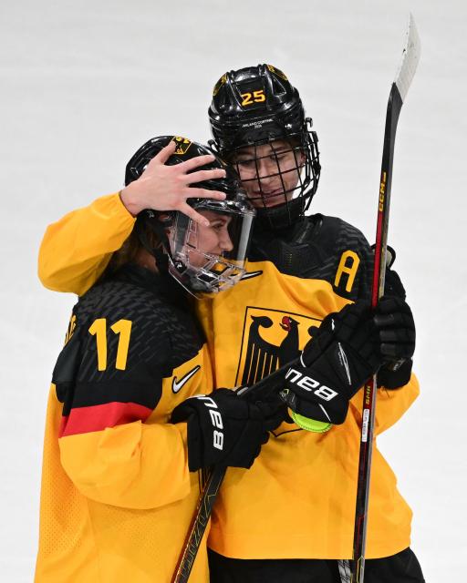 Germany's #25 Laura Kluge (R) celebrates scoring the 2-1 goal with team mate Germany's #11 Nicola Hadraschek during the women's preliminary round Group B Ice Hockey match between Italy and Germany at the Milano Rho Ice Hockey Arena at the Milano Cortina 2026 Winter Olympic Games in Milan, on February 10, 2026. Germany won the match 2-1. (Photo by Piero CRUCIATTI / AFP)
