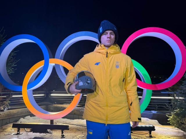 Vladyslav Heraskevych of Ukraine poses with his helmet that serves as a tribute to athletes who have died amid Russia's attack on Ukraine during a press conference in Cortina d'Ampezzo as part of Milano Cortina 2026 Olympic Games, on February 10, 2026. Ukrainian skeleton racer Vladyslav Heraskevych vowed that he would wear his helmet "on race day" despite a ban imposed by Olympic chiefs. (Photo by Andrea BERNARDI / AFP)