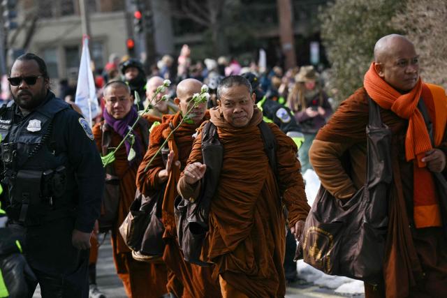 Buddhist monks arrive at the Washington National Cathedral in Washington, DC, on February 10, 2026 before taking part in an interfaith ceremony during the final days of their 2,300-mile "Walk for Peace". (Photo by Drew ANGERER / AFP)