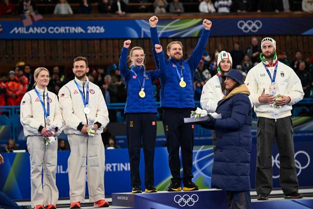 From (L-R) USA's silver medalists Cory Thiesse and Korey Dropkin, Sweden's gold medalists Isabella Wranaa and Rasmus Wrana,  and Italy's bronze medalists Stefania Constantini and Amos Mosaner  celebrate on the podium of the curling mixed doubles event during the Milano Cortina 2026 Winter Olympic Games at the Cortina Curling Olympic Stadium in Cortina d’Ampezzo on February 10, 2026. (Photo by Franзois-Xavier MARIT / AFP)