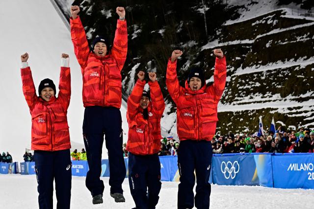 (From L) Bronze medallists Japan's Nozomi Maruyama, Japan's Ryoyu Kobayashi, Japan's Sara Takanashi and Japan's Ren Nikaido celebrate on the podium for the ski jumping mixed team final of the Milano Cortina 2026 Winter Olympic Games at Predazzo Ski Jumping Stadium in Predazzo (Val di Fiemme), on February 10, 2026. (Photo by Tobias SCHWARZ / AFP)