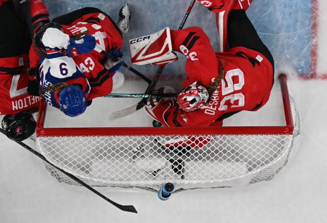 USA's forward #09 Kirsten Simms (3rd L) pushes the puck to the goal leading to a disputed ruling and a goal during the women's preliminary round Group A Ice Hockey match between Canada and USA at the Milano Santagiulia Ice Hockey Arena during the Milano Cortina 2026 Winter Olympic Games in Milan, on February 10, 2026. (Photo by Alexander NEMENOV / AFP)