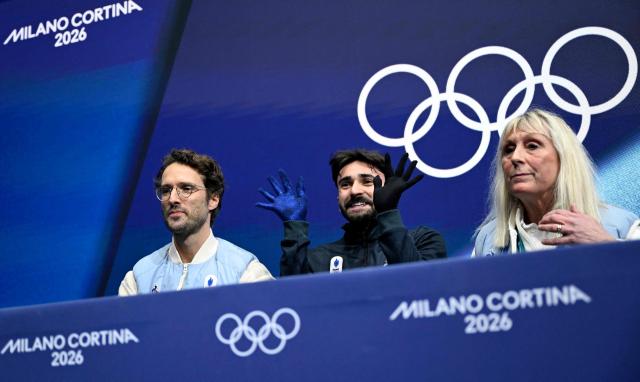 France's Kevin Aymoz reacts at the kiss and cry area after competing in the figure skating men's singles short program during the Milano Cortina 2026 Winter Olympic Games at Milano Ice Skating Arena in Milan on February 10, 2026. (Photo by WANG Zhao / AFP)