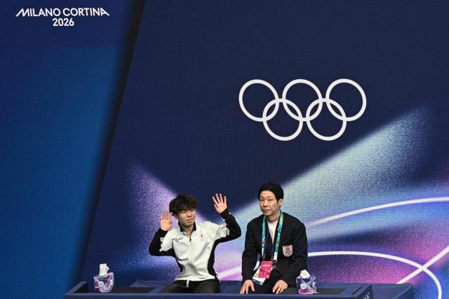 Japan's Shun Sato reacts at the kiss and cry area after competing in the figure skating men's singles short program during the Milano Cortina 2026 Winter Olympic Games at Milano Ice Skating Arena in Milan on February 10, 2026. (Photo by Antonin THUILLIER / AFP)