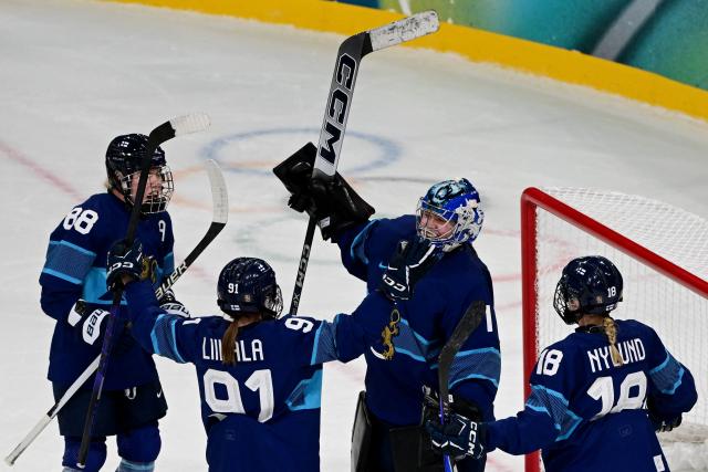 Finland's #01 Sanni Ahola (2R) and team mates celebrate after winning the women's preliminary round Group A Ice Hockey match between Finland and Switzerland at the Milano Rho Ice Hockey Arena during the Milano Cortina 2026 Winter Olympic Games in Milan, on February 10, 2026. Finland won the match 3-1. (Photo by Piero CRUCIATTI / AFP)
