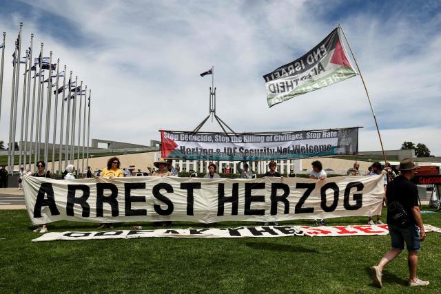 Protesters gather in front of the Parliamment House building ahead of the meeting between Australia's Prime Minister Anthony Albanese and Israel's President Isaac Herzog in Canberra on February 11, 2026. Herzog's tightly secured, four-day trip aims to console Australia's Jewish community after the December shooting at Sydney's Bondi Beach that killed 15 people at a Hanukkah festival. (Photo by David GRAY / AFP)