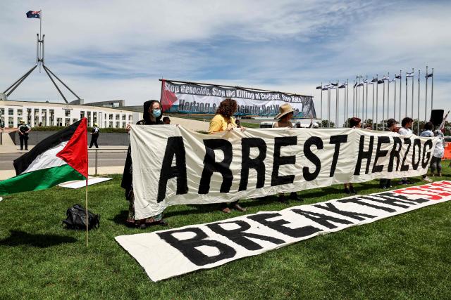 Protesters gather in front of the Parliamment House building ahead of the meeting between Australia's Prime Minister Anthony Albanese and Israel's President Isaac Herzog in Canberra on February 11, 2026. Herzog's tightly secured, four-day trip aims to console Australia's Jewish community after the December shooting at Sydney's Bondi Beach that killed 15 people at a Hanukkah festival. (Photo by David GRAY / AFP)