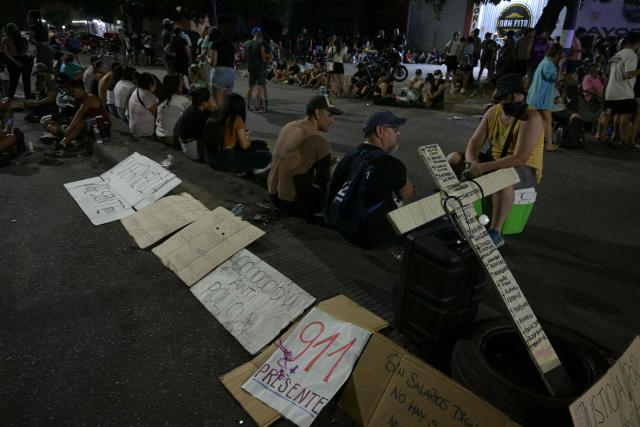 A cross with the names of deceased persons is seen during a police protest demanding better salaries and labor conditions in Rosario, Santa Fe province, Argentina early on February 11, 2026. Several dozen Argentine police officers rebelled in demand of better pay and mental health care in the city of Rosario, the country's most crime-ridden city, in protests that continued into the night of February 10, 2026, after escalating the previous day. (Photo by Juan MABROMATA / AFP)