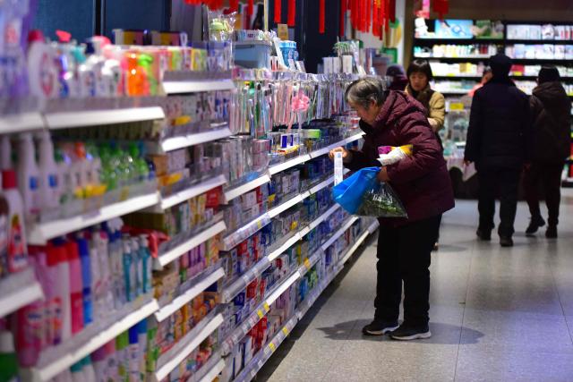 A woman shops at a store in Fuyang, in China’s eastern Anhui province on February 11, 2026. Growth in China's consumer prices slowed last month and missed forecasts, official data showed on February 11, as leaders struggle to kickstart domestic spending in the world's second-largest economy. (Photo by CN-STR / AFP) / China OUT