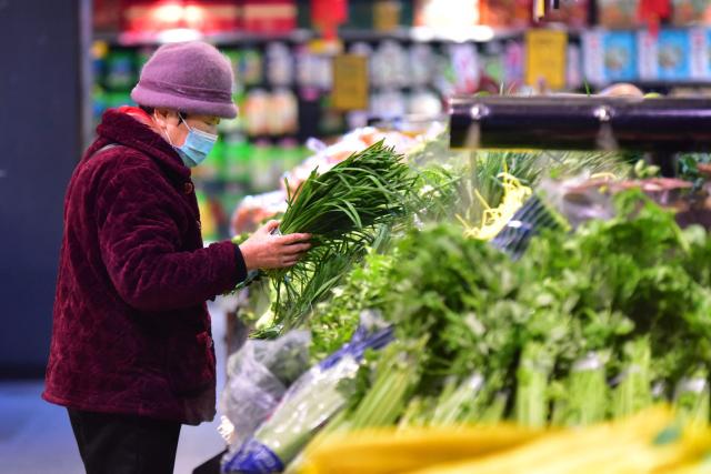 A woman shops for vegetables at a store in Fuyang, in China’s eastern Anhui province on February 11, 2026. Growth in China's consumer prices slowed last month and missed forecasts, official data showed on February 11, as leaders struggle to kickstart domestic spending in the world's second-largest economy. (Photo by CN-STR / AFP) / China OUT
