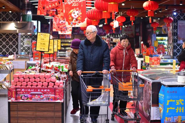 People shop at a store in Fuyang, in China’s eastern Anhui province on February 11, 2026. Growth in China's consumer prices slowed last month and missed forecasts, official data showed on February 11, as leaders struggle to kickstart domestic spending in the world's second-largest economy. (Photo by CN-STR / AFP) / China OUT