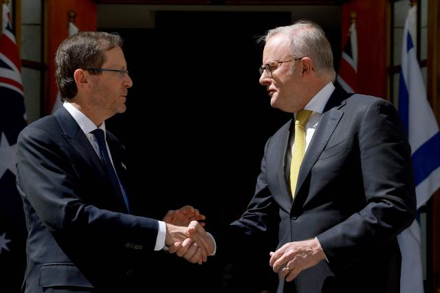 Australia's Prime Minister Anthony Albanese (R) receives Israel's President Isaac Herzog at the Parliament House in Canberra on February 11, 2026. Herzog's tightly secured, four-day trip aims to console Australia's Jewish community after the December shooting at Sydney's Bondi Beach that killed 15 people at a Hanukkah festival. (Photo by DAVID GRAY / AFP)