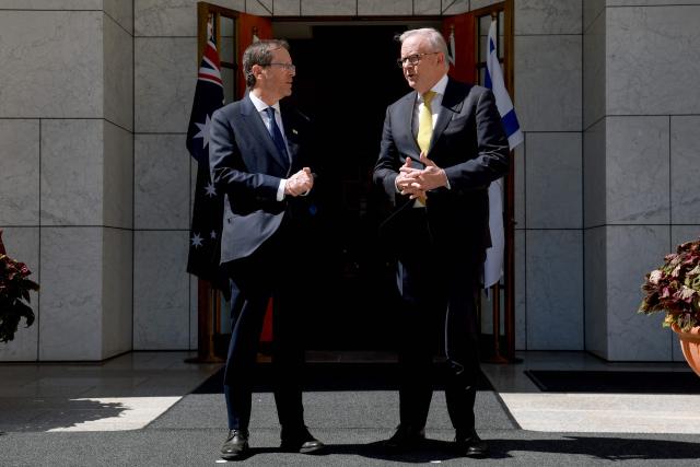 Australia's Prime Minister Anthony Albanese (R) receives Israel's President Isaac Herzog at the Parliament House in Canberra on February 11, 2026. Herzog's tightly secured, four-day trip aims to console Australia's Jewish community after the December shooting at Sydney's Bondi Beach that killed 15 people at a Hanukkah festival. (Photo by DAVID GRAY / AFP)