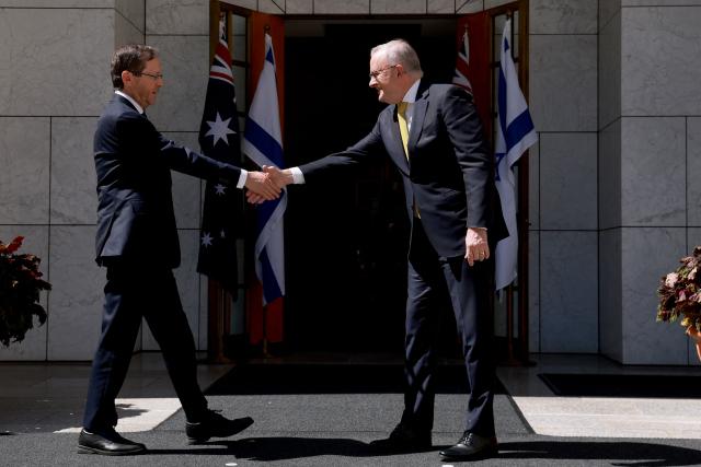 Australia's Prime Minister Anthony Albanese (R) receives Israel's President Isaac Herzog at the Parliament House in Canberra on February 11, 2026. Herzog's tightly secured, four-day trip aims to console Australia's Jewish community after the December shooting at Sydney's Bondi Beach that killed 15 people at a Hanukkah festival. (Photo by DAVID GRAY / AFP)