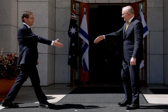 Australia's Prime Minister Anthony Albanese (R) receives Israel's President Isaac Herzog at the Parliament House in Canberra on February 11, 2026. Herzog's tightly secured, four-day trip aims to console Australia's Jewish community after the December shooting at Sydney's Bondi Beach that killed 15 people at a Hanukkah festival. (Photo by DAVID GRAY / AFP)