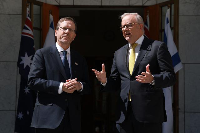 Australia's Prime Minister Anthony Albanese (R) greets Israel's President Isaac Herzog at the Parliament House in Canberra on February 11, 2026. Herzog's tightly secured, four-day trip aims to console Australia's Jewish community after the December shooting at Sydney's Bondi Beach that killed 15 people at a Hanukkah festival. (Photo by DAVID GRAY / AFP)