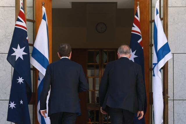 Australia's Prime Minister Anthony Albanese (R) escorts Israel's President Isaac Herzog for a meeting at the Parliament House in Canberra on February 11, 2026. Herzog's tightly secured, four-day trip aims to console Australia's Jewish community after the December shooting at Sydney's Bondi Beach that killed 15 people at a Hanukkah festival. (Photo by DAVID GRAY / AFP)