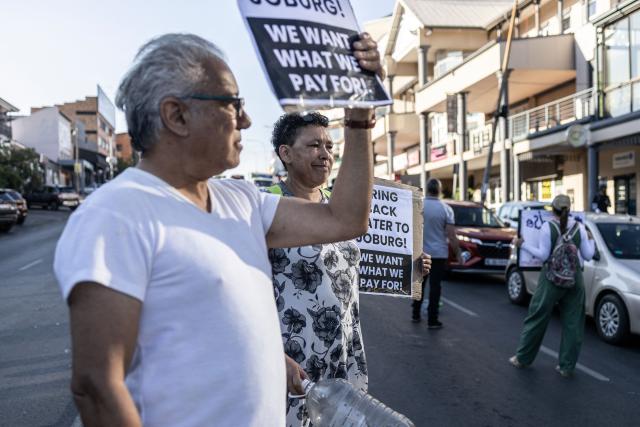 Residents carry placards during a demonstration against water restriction in Melville, Johannesburg, on February 11, 2026. Residents of several parts of Johannesburg are confronted with watercuts, some of them lasting almost a month. (Photo by ILARIA FINIZIO / AFP)