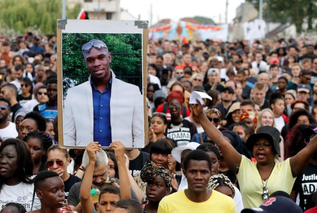 (FILES) A person holds a portrait of late Adama Traore during a march calling for answers two years after the 24-year-old man died in police custody, on July 21, 2018 in Beaumont-sur-Oise, northeast of Paris. France's top court is to rule on February 11, 2026, on the dismissal of an investigation into the 2016 death of a young black man in police custody that sparked protests. (Photo by FRANCOIS GUILLOT / AFP)