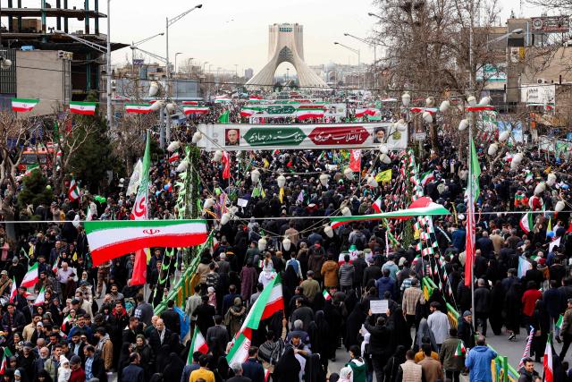 People marching near Azadi Tower in Tehran on February 11, 2026, to mark the 47th anniversary of the 1979 Islamic revolution. The Persian calendar date of Bahman 22 celebrates the anniversary of the resignation of the ousted shah's last prime minister and the formal assumption of power by revolutionary leader Ayatollah Ruhollah Khomeini. (Photo by AFP)