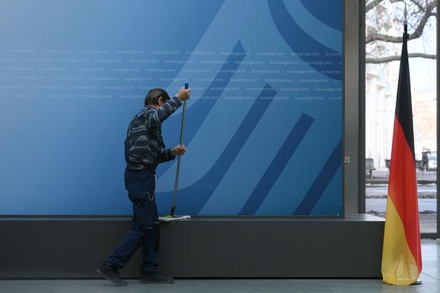 A worker cleans up as preparations are under way for a meeting of the German Foreign Minister with his counterparts from Central Asian countries Turkmenistan, Tajikistan, Kyrgyzstan, Uzbekistan and Kazakhstan, on February 11, 2026 in Berlin. (Photo by RALF HIRSCHBERGER / AFP)