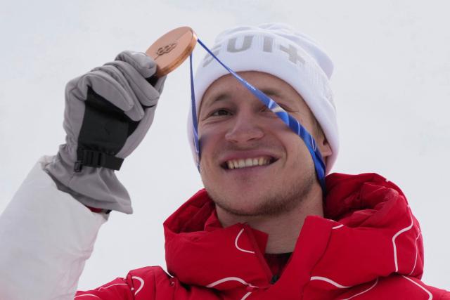 Switzerland's bronze medalist Marco Odermatt holds up his medal on the podium of the men's super-G alpine skiing event during the Milano Cortina 2026 Winter Olympic Games at the Stelvio Ski Centre in Bormio (Valtellina) on February 11, 2026. (Photo by Dimitar DILKOFF / AFP)