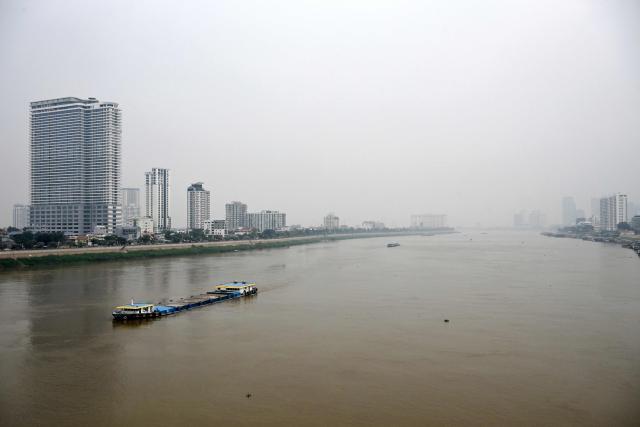 A general view shows heavy air pollution conditions over the Tonle Sap River in Phnom Penh on February 11, 2026. (Photo by TANG CHHIN Sothy / AFP)