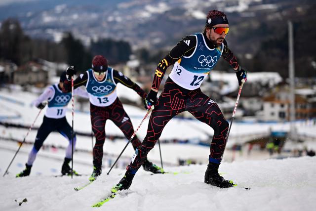 Japan's Akito Watabe, Germany's Julian Schmid and Germany's Johannes Rydzek compete in the cross-country of the nordic combined individual Gundersen normal hill/10km competition event at Tesero Cross Country Stadium at Lago di Tesero (Val di Fiemme) during the Milano Cortina 2026 Winter Olympic Games on February 11, 2026. (Photo by Tobias SCHWARZ / AFP)