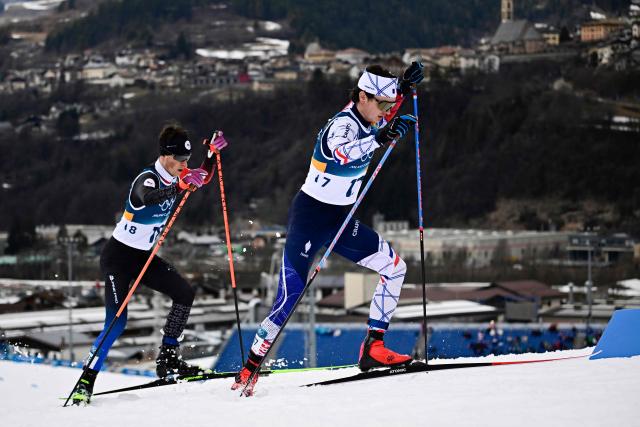 Czech Republic's Jiri Konvalinka (L) and France's Marco Heinis compete in the cross-country of the nordic combined individual Gundersen normal hill/10km event at Tesero Cross Country Stadium at Lago di Tesero (Val di Fiemme) during the Milano Cortina 2026 Winter Olympic Games on February 11, 2026. (Photo by Tobias SCHWARZ / AFP)