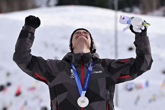 Silver medalist Austria's Johannes Lamparter celebrates on the podium following the nordic combined individual Gundersen normal hill/10km event at Tesero Cross Country Stadium at Lago di Tesero (Val di Fiemme) during the Milano Cortina 2026 Winter Olympic Games on February 11, 2026. (Photo by Javier SORIANO / AFP)