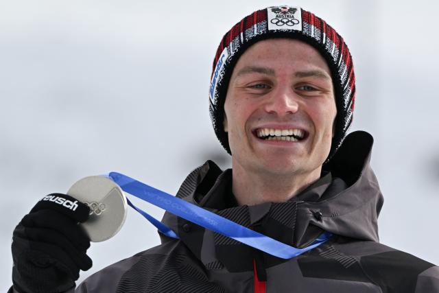 Silver medalist Austria's Johannes Lamparter celebrates on the podium following the nordic combined individual Gundersen normal hill/10km event at Tesero Cross Country Stadium at Lago di Tesero (Val di Fiemme) during the Milano Cortina 2026 Winter Olympic Games on February 11, 2026. (Photo by Javier SORIANO / AFP)