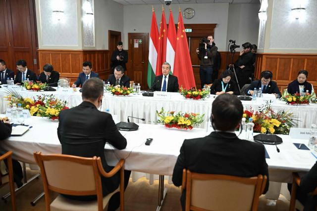 Chinese Foreign Minister Wang Yi (background, C) listens to his host Hungarian Foreign and Trade Minister Peter Szijjarto (foreground, L) as they meet in Budapest, Hungary, on February 11, 2026. (Photo by Attila KISBENEDEK / AFP)