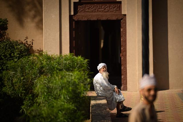 An old man sits in front of the entrance of the souk of Nizwa, prior to the presentation of the 5th and last stage of the Tour of Oman cycling race from Nizwa to Green Mountain, on February 11, 2026. (Photo by Loic VENANCE / AFP)