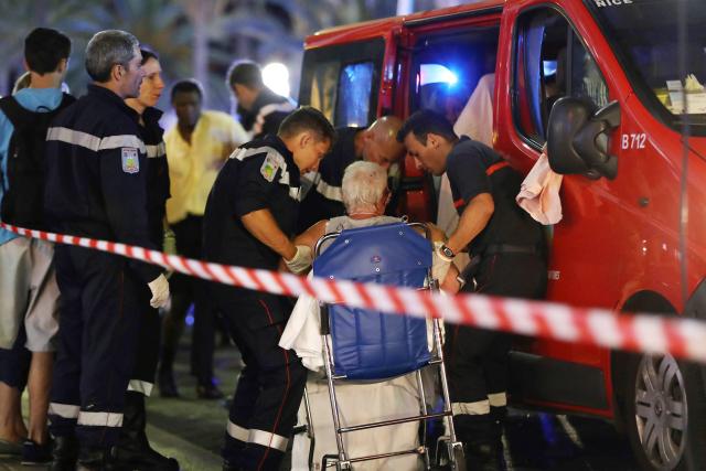 (FILES) Rescue workers help an injured woman to get in a ambulance on July 15, 2016, after a truck drove into a crowd watching a fireworks display in the French Riviera town of Nice. On February 11, 2026, the Court of Cassation made final the eighteen-year prison sentences of the two main defendants in the trials over the 2016 Nice attack—the only ones who had appealed—AFP learned from a judicial source. (Photo by Valery HACHE / AFP)