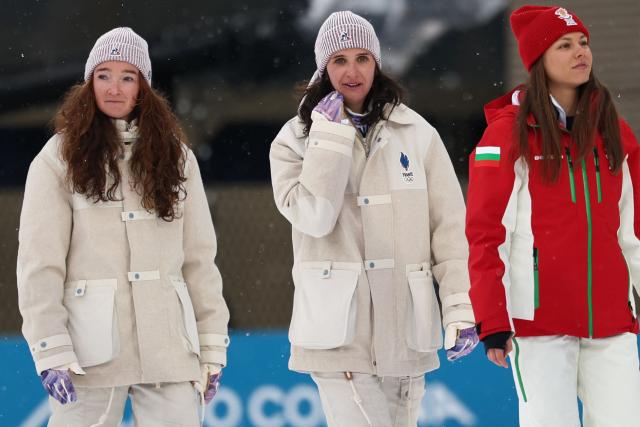 (L-R) Silver medallist France's Lou Jeanmonnot, gold medallist France's Julia Simon and bronze medallist Bulgaria's Lora Hristova pose on the podium of the women's biathlon 15km individual event during the Milano Cortina 2026 Winter Olympic Games at the Anterselva Biathlon Arena (Sudtirol Arena) in Anterselva (Val Pusteria) on February 11, 2026. (Photo by FRANCK FIFE / AFP)