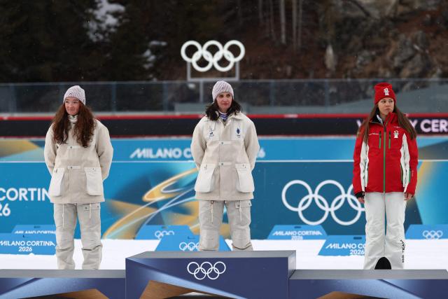(L-R) Silver medallist France's Lou Jeanmonnot, gold medallist France's Julia Simon and bronze medallist Bulgaria's Lora Hristova pose on the podium of the women's biathlon 15km individual event during the Milano Cortina 2026 Winter Olympic Games at the Anterselva Biathlon Arena (Sudtirol Arena) in Anterselva (Val Pusteria) on February 11, 2026. (Photo by FRANCK FIFE / AFP)