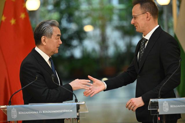 Hungarian Foreign and Trade Minister Peter Szijjarto (R) and Chinese Foreign Minister Wang Yi shake hands after their joint press conference in Budapest, Hungary, on February 11, 2026. (Photo by Attila KISBENEDEK / AFP)