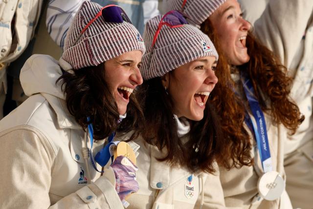 Gold medallist France's Julia Simon (L) poses with France's Camille Bened (C) and silver medallist France's Lou Jeanmonnot after the victory ceremony of the women's biathlon 15km individual event during the Milano Cortina 2026 Winter Olympic Games at the Anterselva Biathlon Arena (Sudtirol Arena) in Anterselva (Val Pusteria) on February 11, 2026. (Photo by Odd ANDERSEN / AFP)