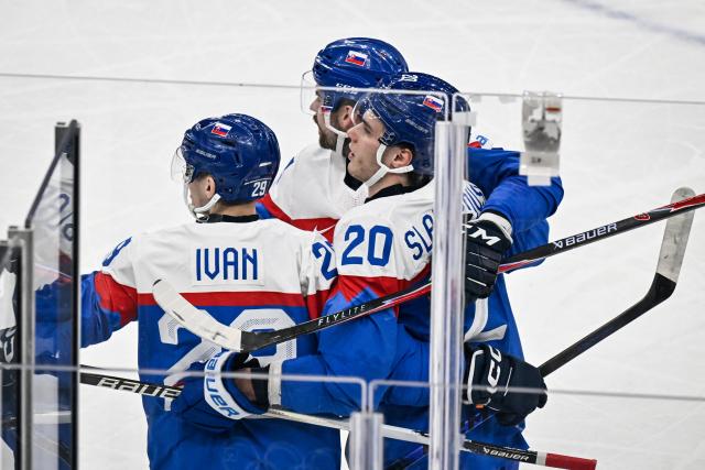 Slovakia's #20 Juraj Slafkovsky (R) celebrates with teammates after scoring his team first goal during the men's preliminary round Group B Ice Hockey match between Slovakia and Finland at the Milano Santagiulia Ice Hockey Arena during the Milano Cortina 2026 Winter Olympic Games in Milan, on February 11, 2026. (Photo by Alexander NEMENOV / AFP)