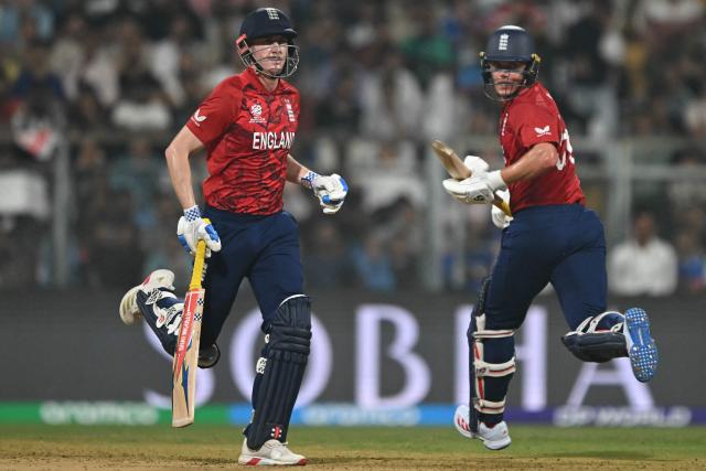 England's Sam Curran and captain Harry Brook run between the wickets during the 2026 ICC Men's T20 Cricket World Cup group stage match between England and West Indies at the Wankhede Stadium in Mumbai on February 11, 2026. (Photo by Indranil MUKHERJEE / AFP)