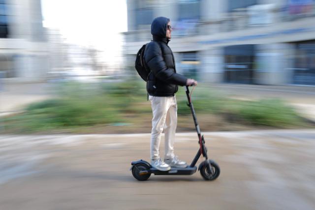 A man rides a scooter in Montpellier, southern France on February 11, 2026. The city of Montpellier issued a decree on November 2025 banning the use of electric scooters and similar vehicles in the Place de la Comédie, the Antigone district, and the main pedestrian streets of the historic center. (Photo by Sylvain THOMAS / AFP)